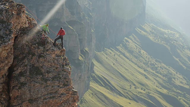 一群登山者站在悬崖边讨论行动计划。