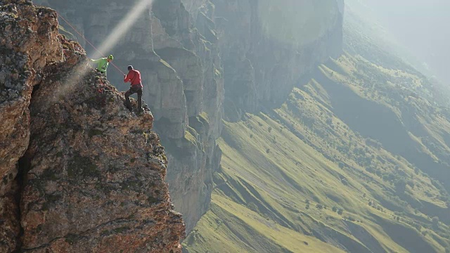 詳情圖-一群登山者站在懸崖邊討論行動計劃。