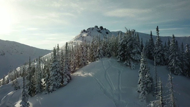 无人机上的滑雪者滑雪在雪山上排成一条线。