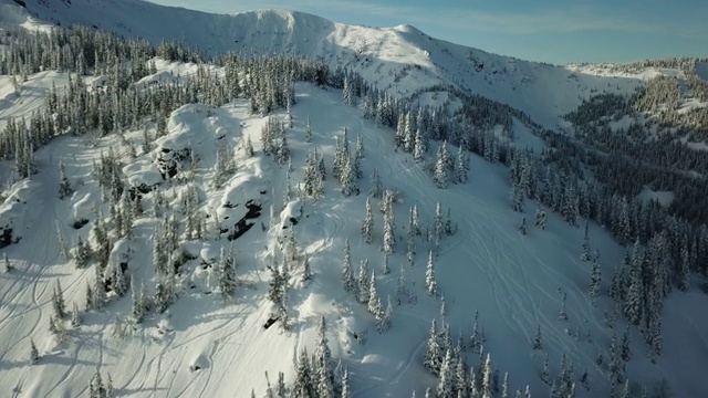 无人机上的滑雪者滑雪在雪山上排成一条线。