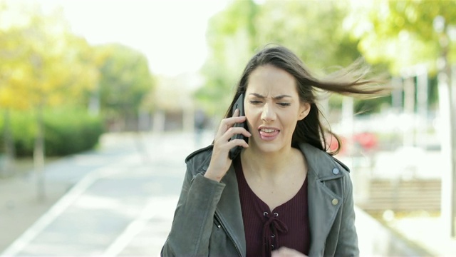 一个愤怒的女人在公园里打电话争吵