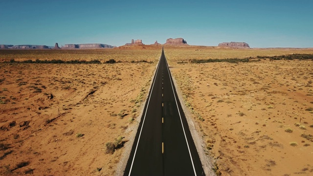 詳情圖-無人機向后飛行在紀念碑谷標志性的空砂巖沙漠道路，亞利桑那州與巨大的懸崖山脈。