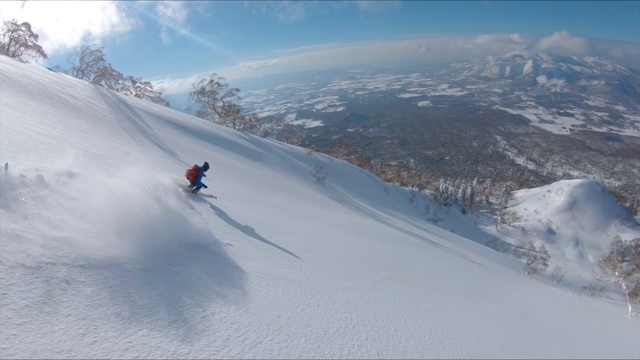 詳情圖-無人機:自由式滑雪者在風(fēng)景優(yōu)美的山上騎行時撕碎積雪。