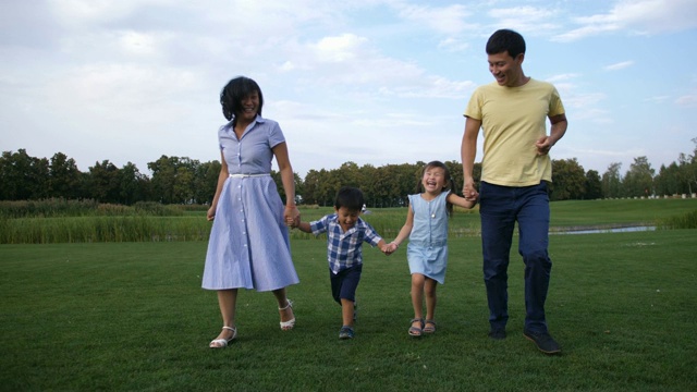 詳情圖-亞洲家庭牽手在公園里跑步
