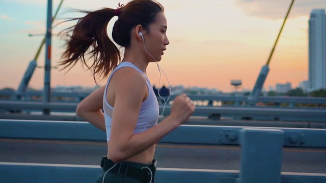 詳情圖-日落，年輕女子慢跑過橋的慢鏡頭