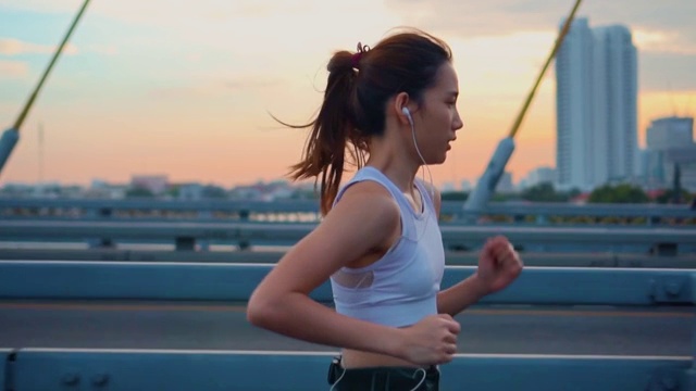 詳情圖-日落，年輕女子慢跑過橋的慢鏡頭