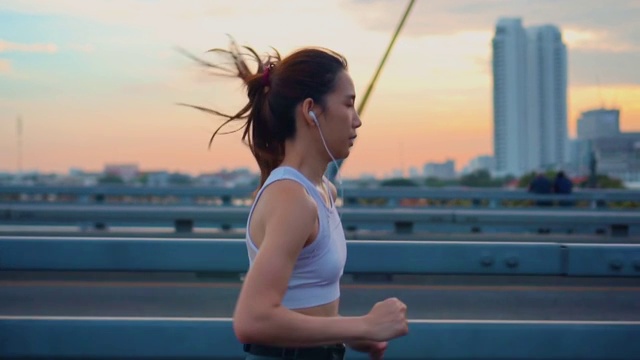 詳情圖-日落，年輕女子慢跑過橋的慢鏡頭