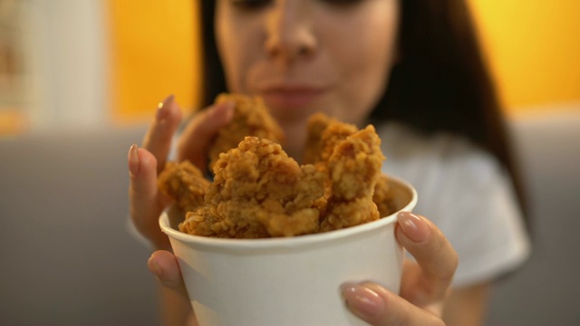 人给饥饿的女孩烤鸡翅，美味肥美的快餐