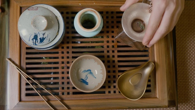 师傅把热水倒进碗里，茶水从上往下倒。茶道