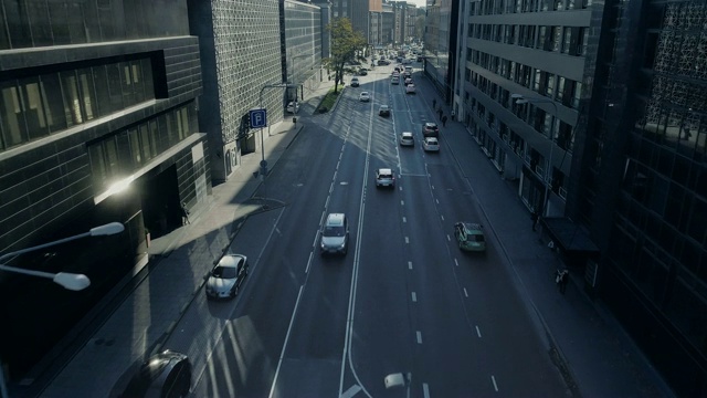 自上而下的无人机跟踪拍摄的汽车在高速公路上通过城市交通在白天。