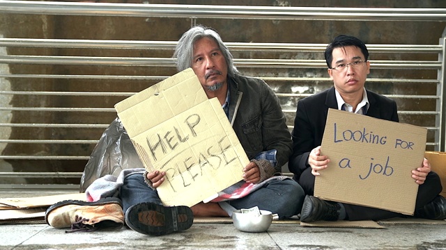 被解雇的办公室职员在街上乞讨和无家可归的人坐在一起。经济危机，经济改革观念。