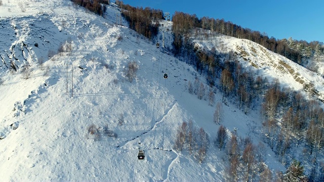 详情图-在冬天飞过森林里的滑雪缆车。鸟瞰图滑雪缆车在雪山。冬季滑雪和单板滑雪的好天气。