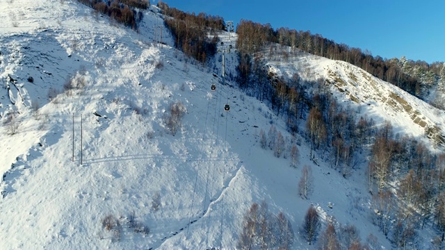 详情图-在冬天飞过森林里的滑雪缆车。鸟瞰图滑雪缆车在雪山。冬季滑雪和单板滑雪的好天气。