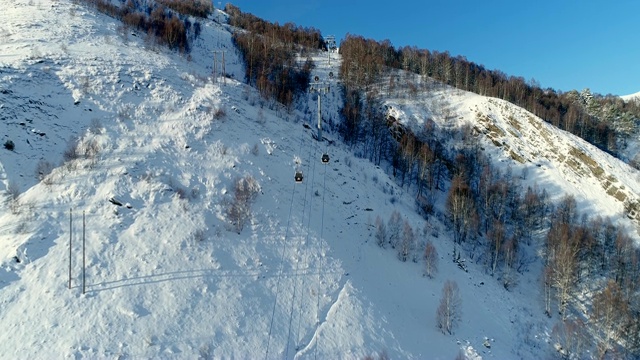 详情图-在冬天飞过森林里的滑雪缆车。鸟瞰图滑雪缆车在雪山。冬季滑雪和单板滑雪的好天气。