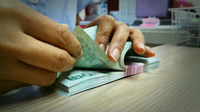 出纳员正在数办公费用的金额