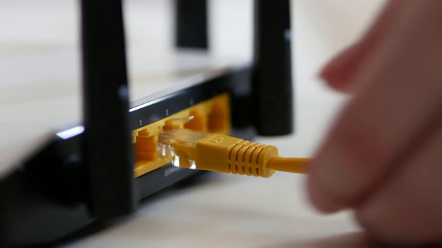 WiFi路由器的女性手插以太网电缆