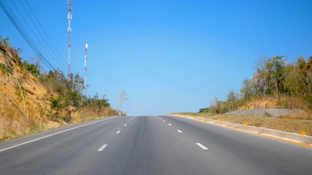 在道路旁边有森林和晴朗的天空