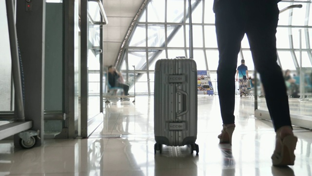 详情图-带着旅行袋在机场候机楼或地铁里行走的商务女性