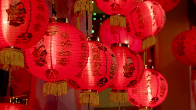 中国新年的灯笼装饰在唐人街，文字意味着好运和幸福。