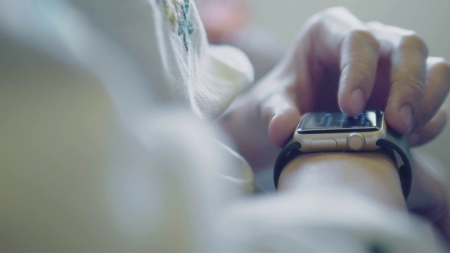 女人在用他的智能手表。她正在查看电子邮件、短信或使用移动应用程序。