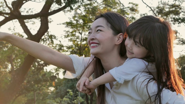 詳情圖-生活方式的母親和女兒在幸福的在野外在日落的光。家人在做節(jié)日活動(dòng)。亞洲家庭在花園里玩耍。幸福的家庭的概念。放松的育兒