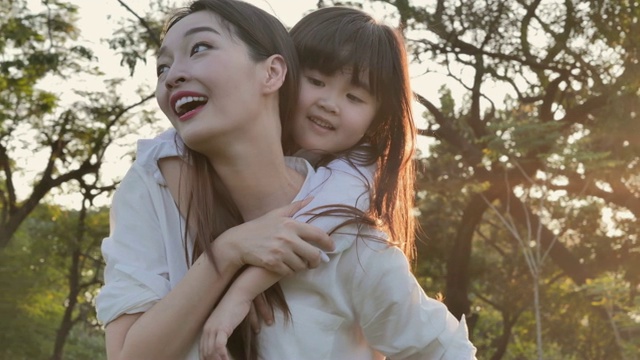詳情圖-生活方式的母親和女兒在幸福的在野外在日落的光。家人在做節(jié)日活動(dòng)。亞洲家庭在花園里玩耍。幸福的家庭的概念。放松的育兒