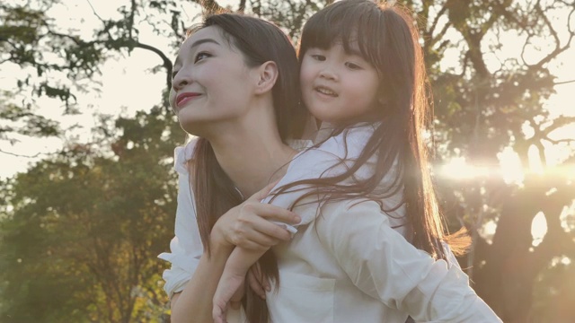 詳情圖-生活方式的母親和女兒在幸福的在野外在日落的光。家人在做節(jié)日活動(dòng)。亞洲家庭在花園里玩耍。幸福的家庭的概念。放松的育兒