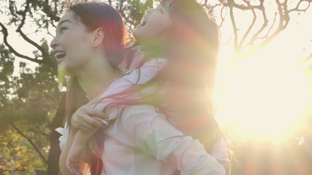 詳情圖-生活方式的母親和女兒在幸福的在野外在日落的光。家人在做節(jié)日活動(dòng)。亞洲家庭在花園里玩耍。幸福的家庭的概念。放松的育兒