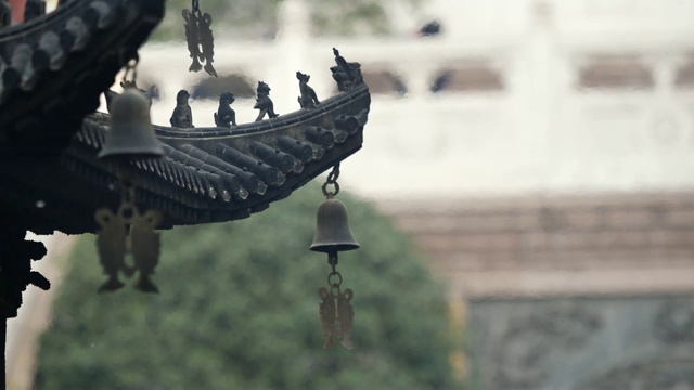 上海静安寺建筑屋檐上的神仙和野兽，御黄屋顶装饰，屋檐下的风铃随风摇摆，4K视频，慢镜头。