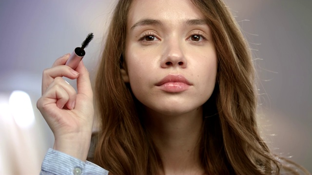 在睫毛上涂睫毛膏的女人。正在化妆的女孩