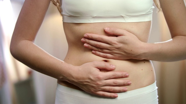 女人身体感到腹痛。月经疼痛。疾病在身体上痉挛