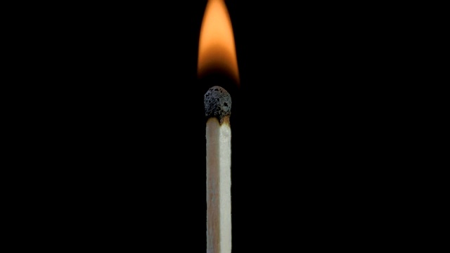 火柴自燃，燃烧，熄灭。燃烧的木头火柴和火焰特写在一个黑色的背景上壮观的燃烧着的火，燃烧到最后留下一个烧焦的木头火柴。特写镜头