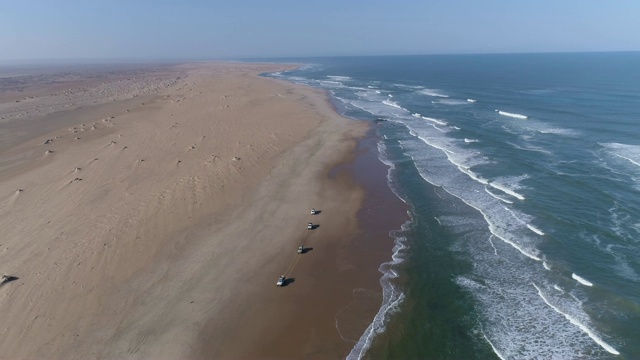 4K天线缩小视野的车队4x4车辆行驶在骸骨海岸，纳米布沙漠，纳米比亚