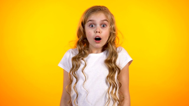 可爱的害怕的女学生紧闭的脸与手掌，幼稚的恐惧，意想不到的消息