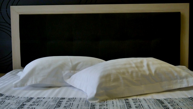 卧室室内装饰。旅馆房间里的双人床。清洗干净的床单和枕套。