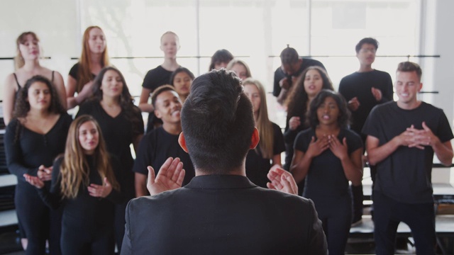 男女学生在表演艺术学校与老师合唱