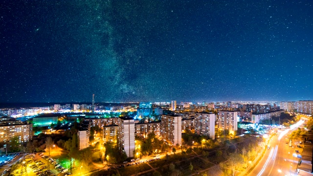 在星空背景下的美丽的夜城景色。时间流逝