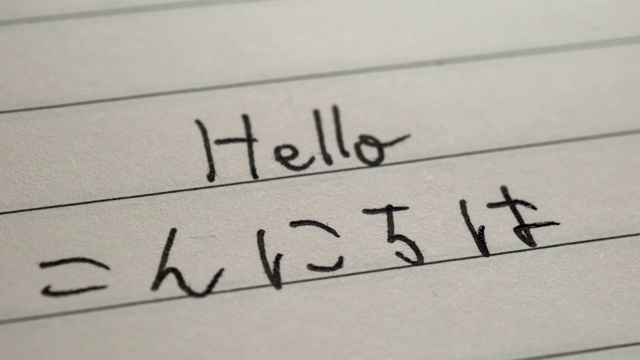 初学日语的人在笔记本上用日语平假名写下“你好”字