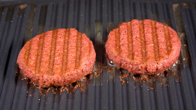 关闭植物为基础的汉堡肉饼在煎锅上被烤