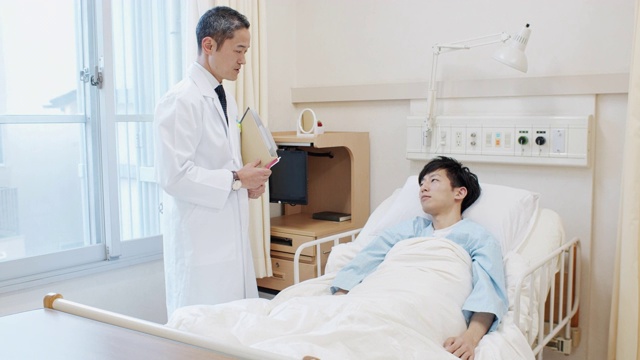 日本医生在病床上对病人说话