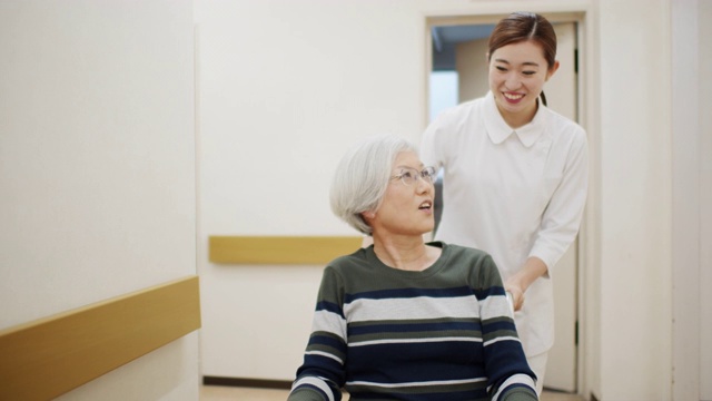 护士用轮椅推病人走过医院走廊
