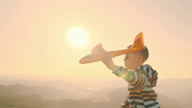 详情图-快乐的旅行者男孩在阳光明媚的一天在公园玩飞机玩具。4K慢动作视频。日落时分，孩子在山顶上奔跑。宇宙边缘之旅