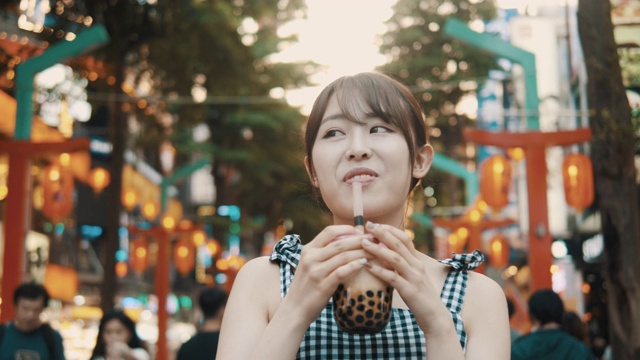 石门亭购物区亚洲年轻女子喝珍珠奶茶(慢镜头)