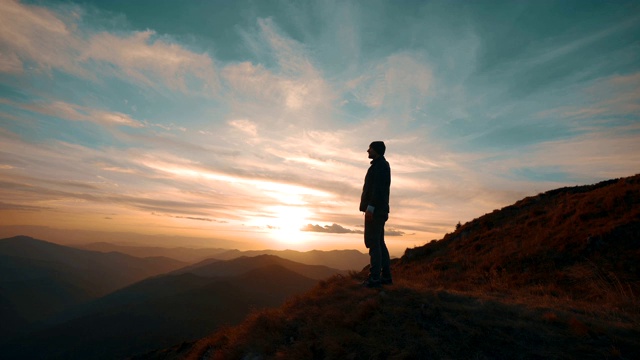 详情图-一个人站在山上，映衬着美丽的夕阳