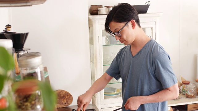 詳情圖-(中景)一個年輕人正在家里做飯