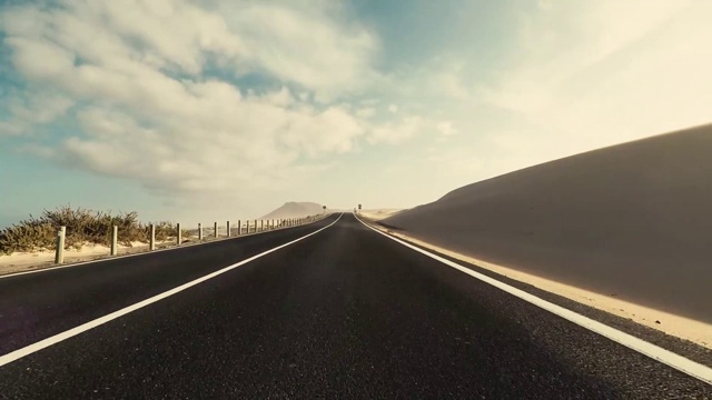 长路在山与太阳在前面和阳光的效果-地面点与黑色沥青和白色线-驾驶和旅行的概念