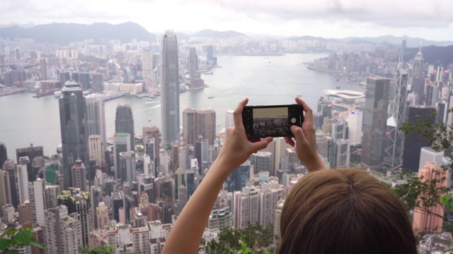 旅行者正在用手机拍摄香港城市的照片