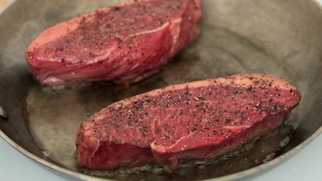 厨师把牛排翻过来，露出焦糖化的肉