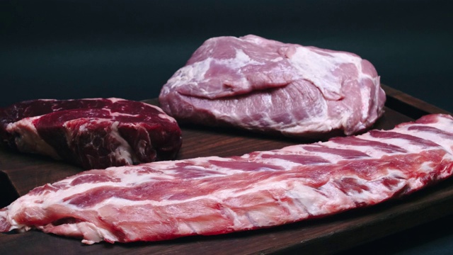 排骨、肉浆和琥珀色的牛肉在4k分辨率的木板上旋转