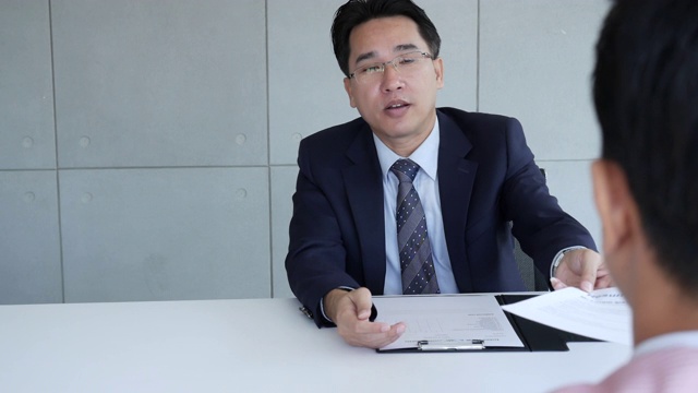 工作人力资源申请人有一个面试与人力资源经理的工作面试与自信的候选人在商业公司办公室给简历。与猎头公司和申请人进行面试